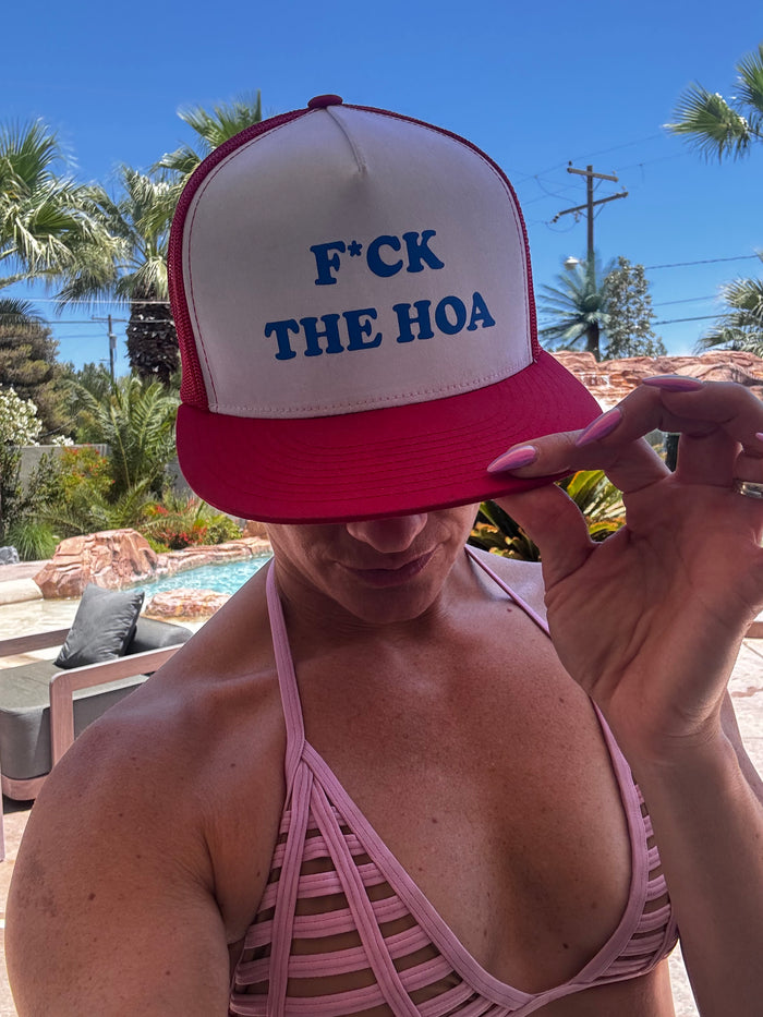 Customer showing the red hat beside a sunny pool
